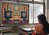 a woman in a colorful sari staring at a computer which shows a colorful tye dye pattern