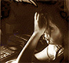a pixelated and dark image of a girl with tousled hair staring at a computer screen